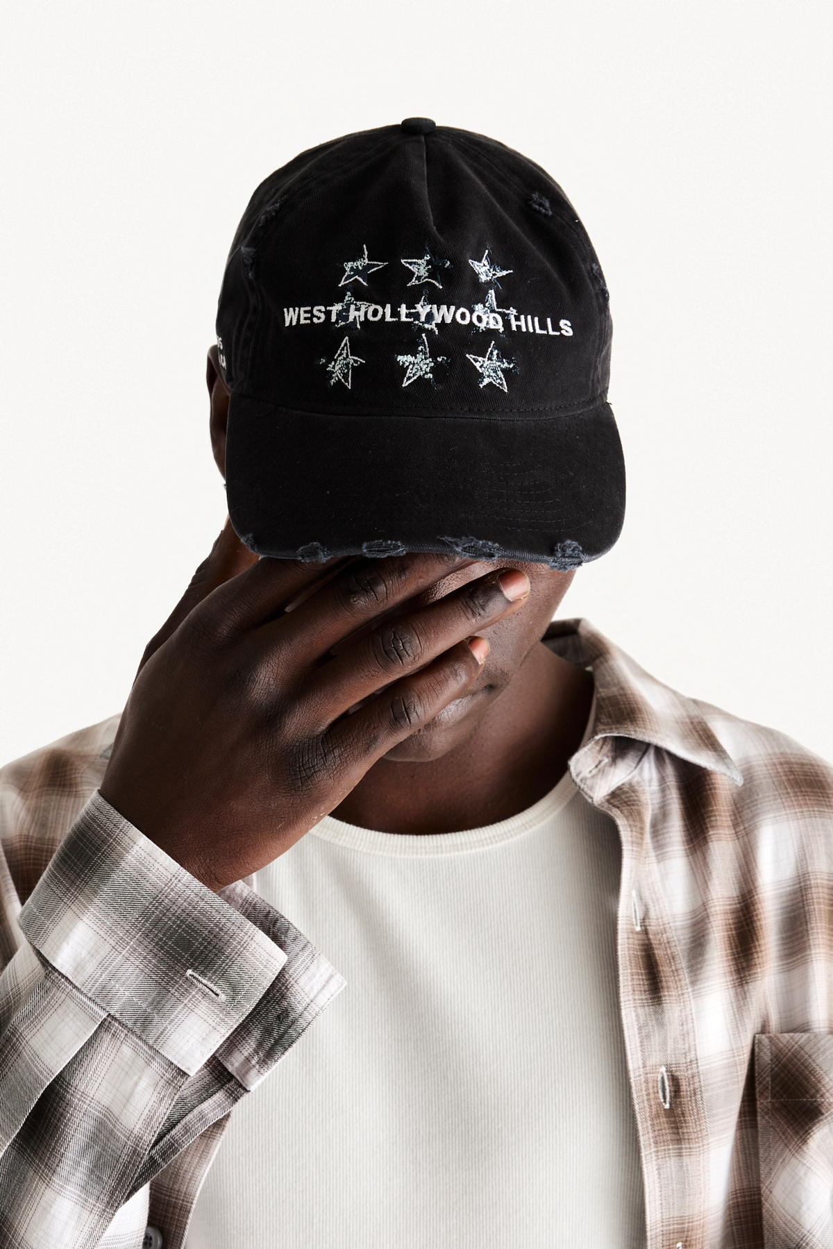 Hollywood Cap - Black, on-body front view, hand over face