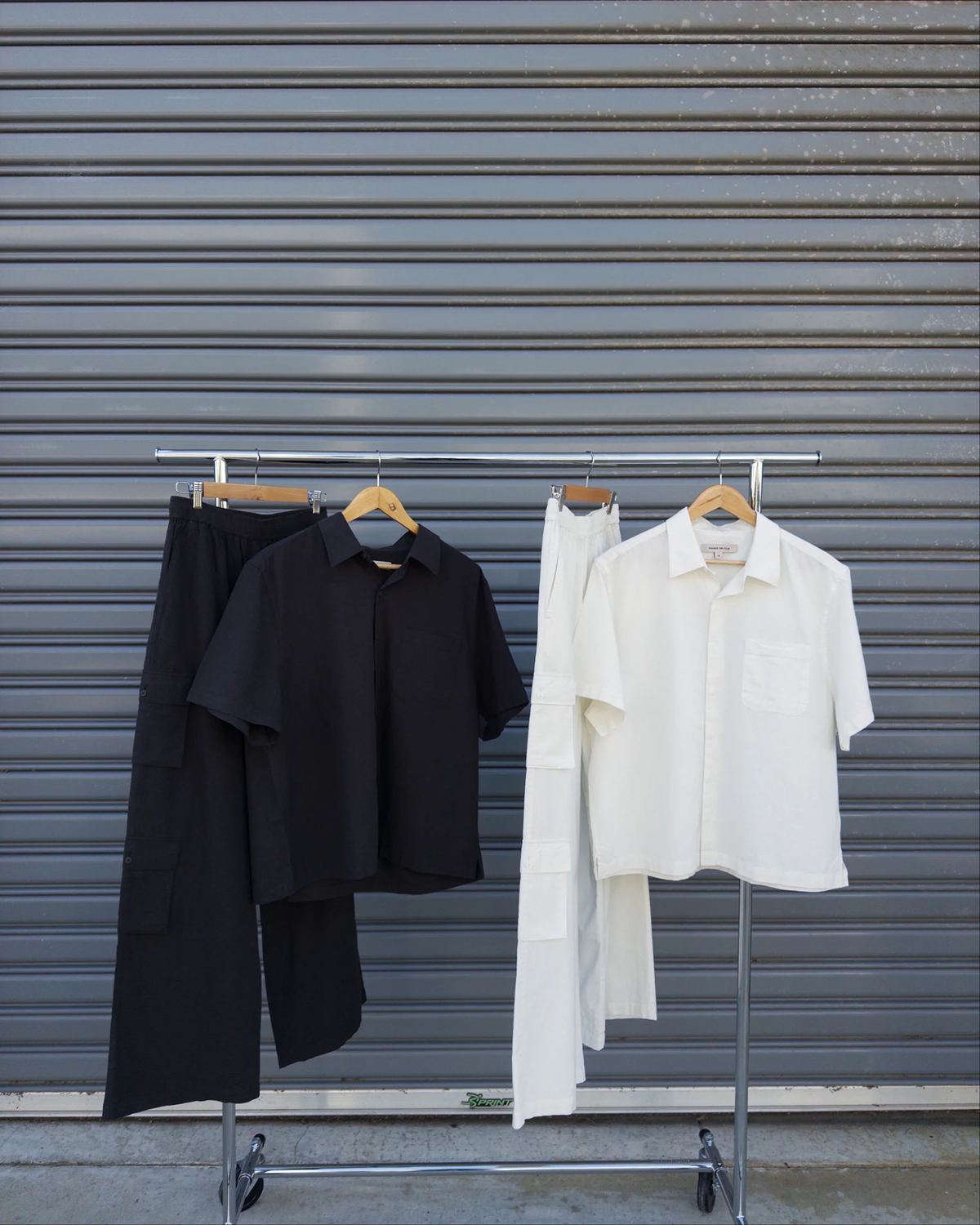Black and white Summer Shirts and Summer Cargo Pants hanging in the studio.